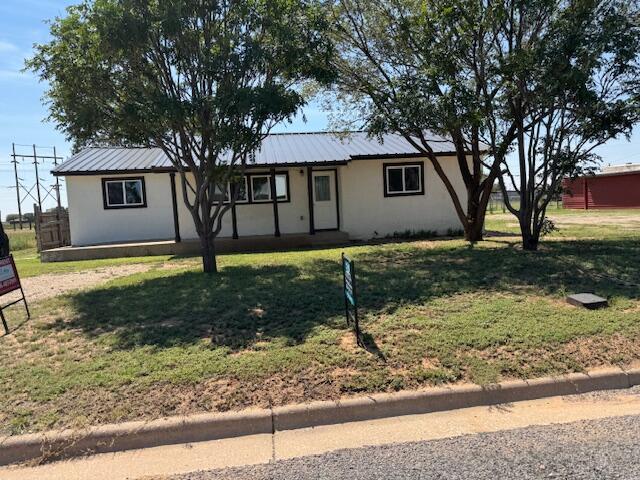 1126 East 15th Street Littlefield, TX 79339 - Photo 1 of 13 a front view of a house with a yard and trees
