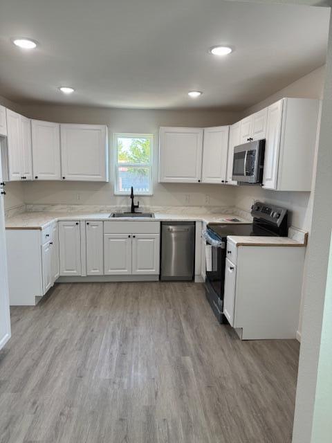 1126 East 15th Street Littlefield, TX 79339 - Photo 4 of 13 a kitchen with stainless steel appliances granite countertop a stove top oven a sink dishwasher and white cabinets with wooden floor