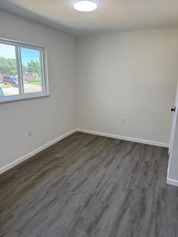 a view of a room that has wooden floor and large window