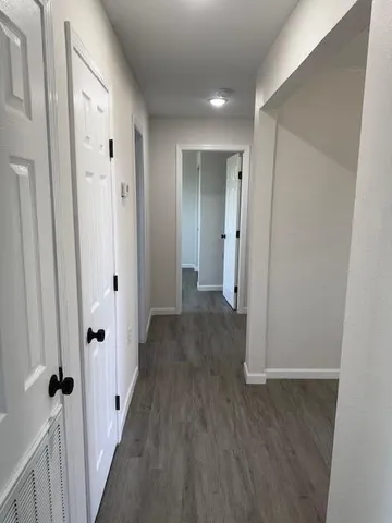 a view of a hallway with wooden floor