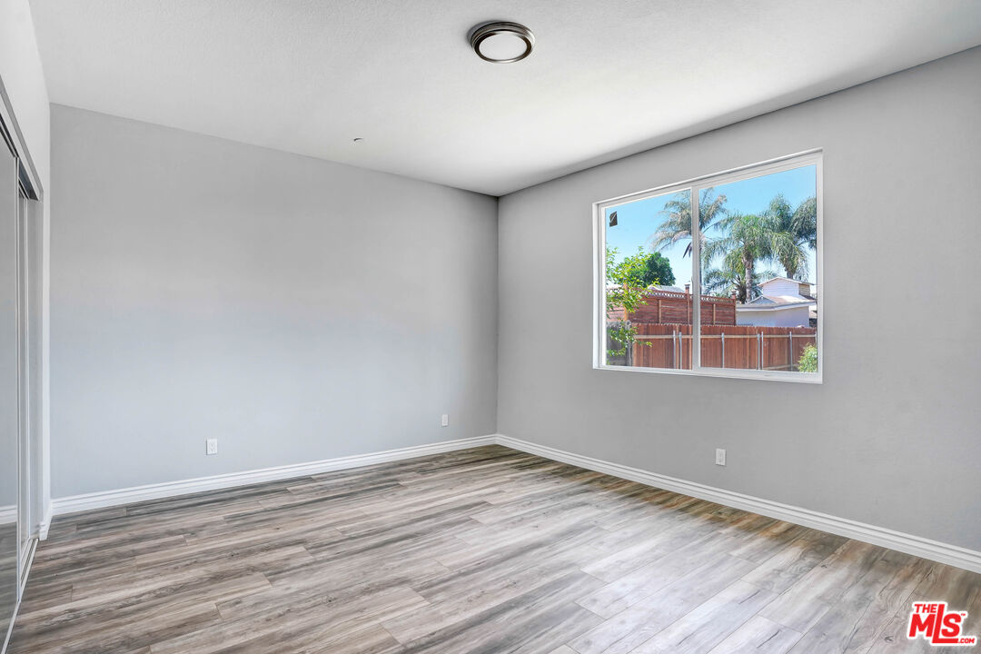 1047 West H Street Colton, CA 92324 - Photo 9 of 13 a view of an empty room with wooden floor and a window