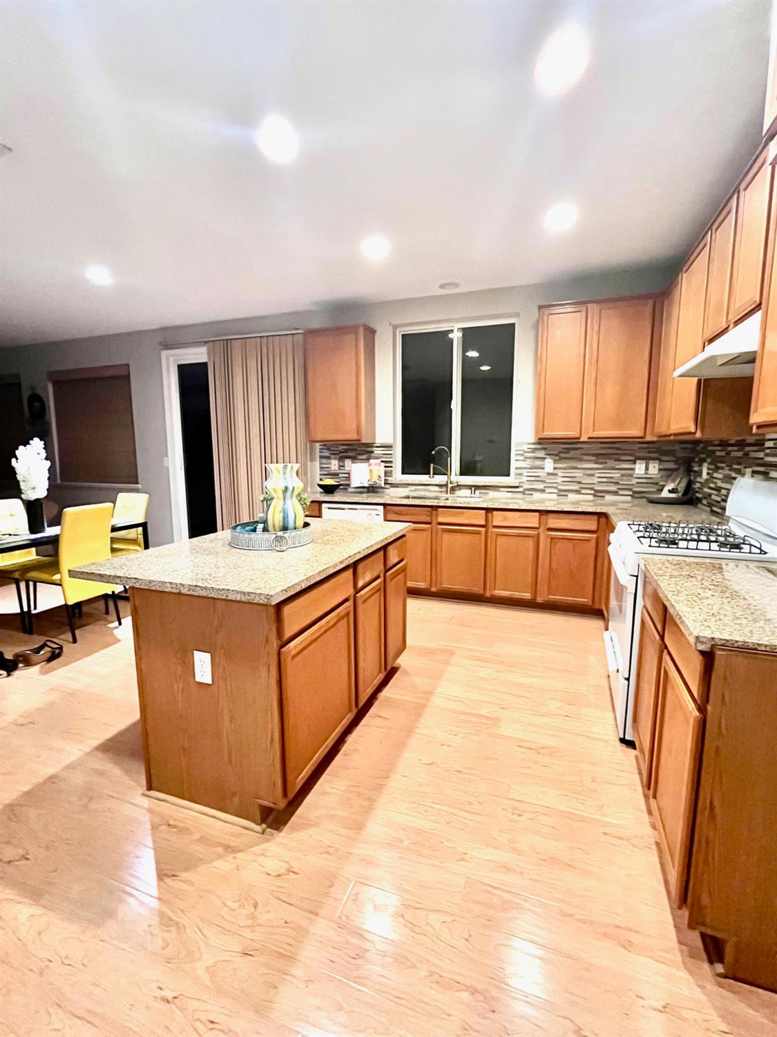 1450 Longhorn Lane Patterson, CA 95363 - Photo 26 of 32 a large kitchen with stainless steel appliances kitchen island granite countertop a stove top oven a sink dishwasher and cabinets with wooden floor