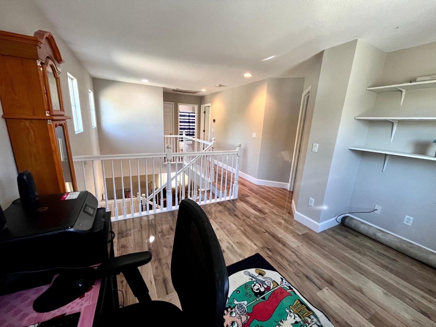 1450 Longhorn Lane Patterson, CA 95363 - Photo 3 of 32 a view of a hallway with furniture and wooden floor