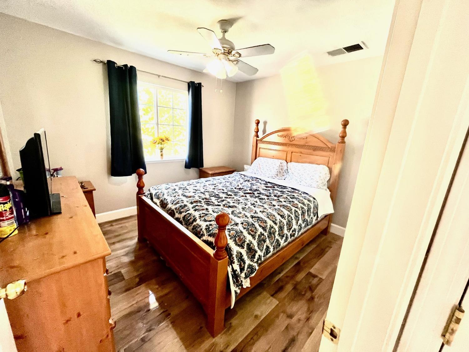 1450 Longhorn Lane Patterson, CA 95363 - Photo 5 of 32 a bedroom with a bed and wooden floor