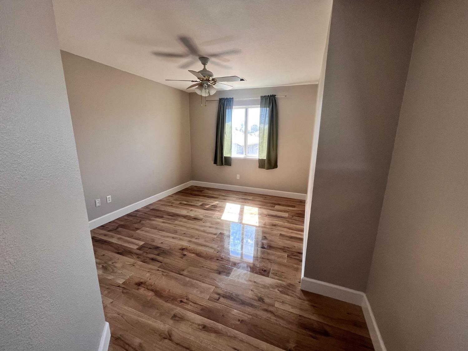 1450 Longhorn Lane Patterson, CA 95363 - Photo 6 of 32 a view of empty room with wooden floor and fan