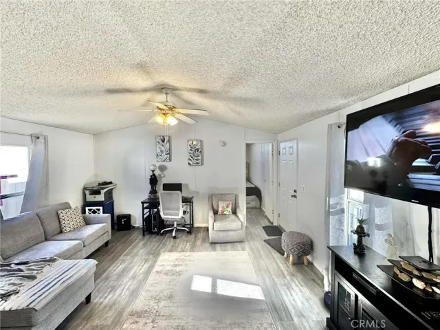 a kitchen with stainless steel appliances kitchen island granite countertop a refrigerator a stove a sink dishwasher and white cabinets with wooden floor