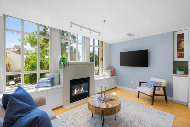 a living room with furniture a flat screen tv and a fireplace