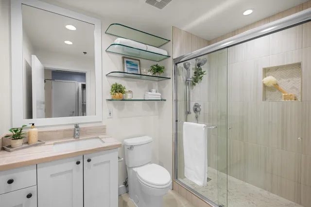 a bathroom with a granite countertop sink toilet and shower