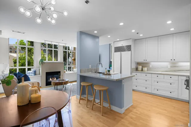 a kitchen with kitchen island granite countertop a table chairs sink and cabinets