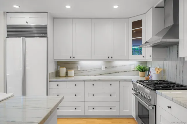 a kitchen with stainless steel appliances granite countertop a stove and a refrigerator