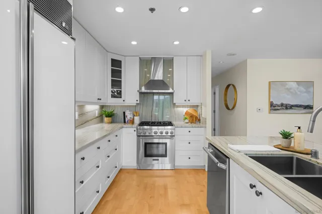 a kitchen with stainless steel appliances granite countertop a sink stove and refrigerator