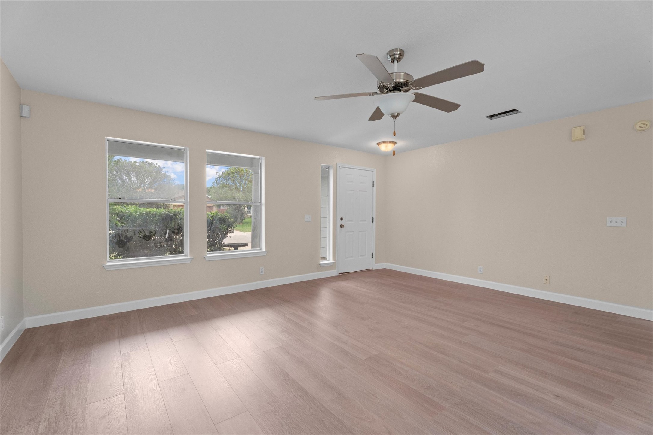 172 Discovery Kyle, TX 78640 - Photo 2 of 21 Spacious living area with large windows, ceiling fan, and plenty of natural light.