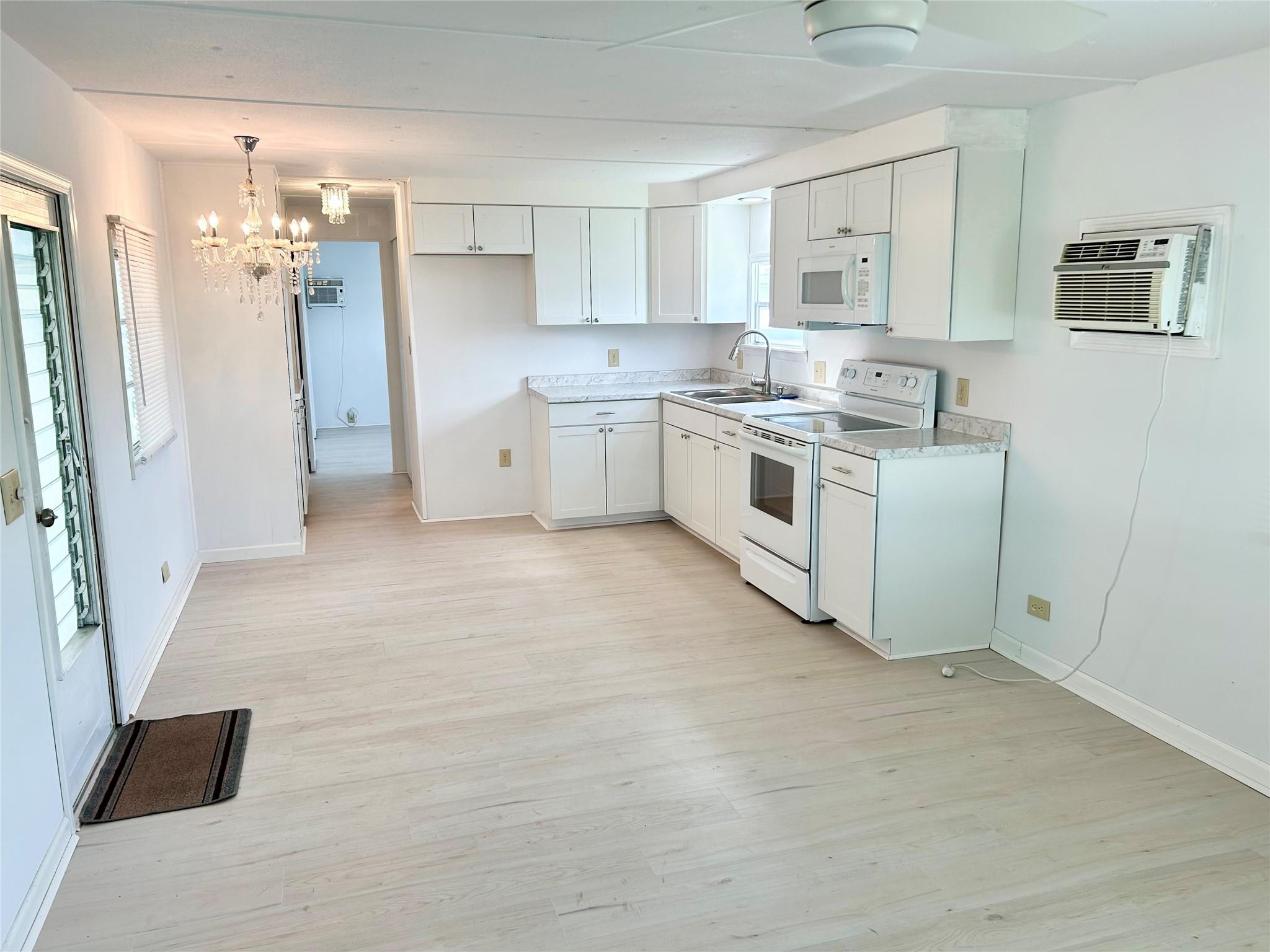 5400 Southeast Jack Avenue Stuart, FL 34997 - Photo 4 of 20 a kitchen with white cabinets and white appliances