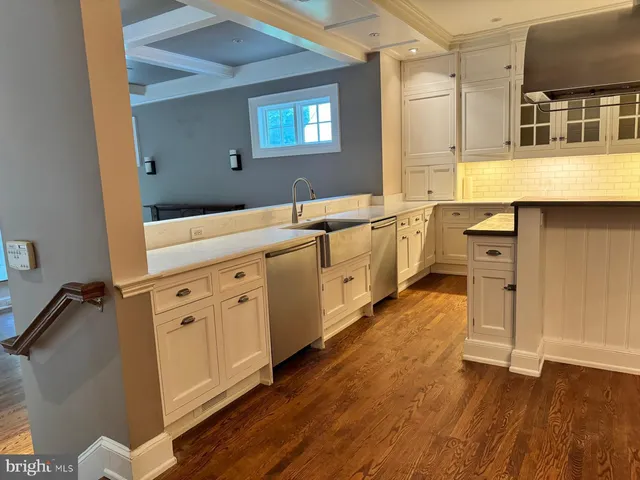 a kitchen with stainless steel appliances granite countertop a refrigerator a stove and a wooden floors