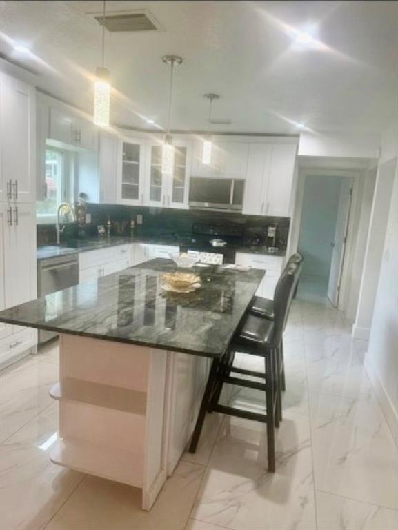 3111 Thames Way Miramar, FL 33025 - Photo 8 of 18 a kitchen with stainless steel appliances granite countertop table chairs and granite counter tops
