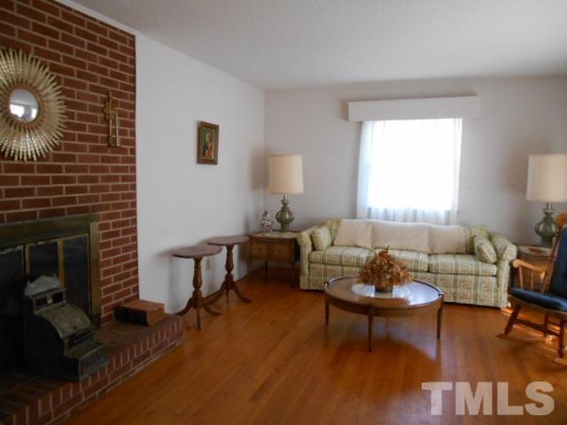 6591 Dwight Rowland Road Willow Spring, NC 27592 - Photo 12 of 16 a living room with furniture and a fireplace