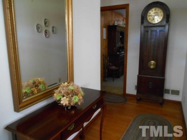 6591 Dwight Rowland Road Willow Spring, NC 27592 - Photo 13 of 16 a living room with painting on the wall and a table