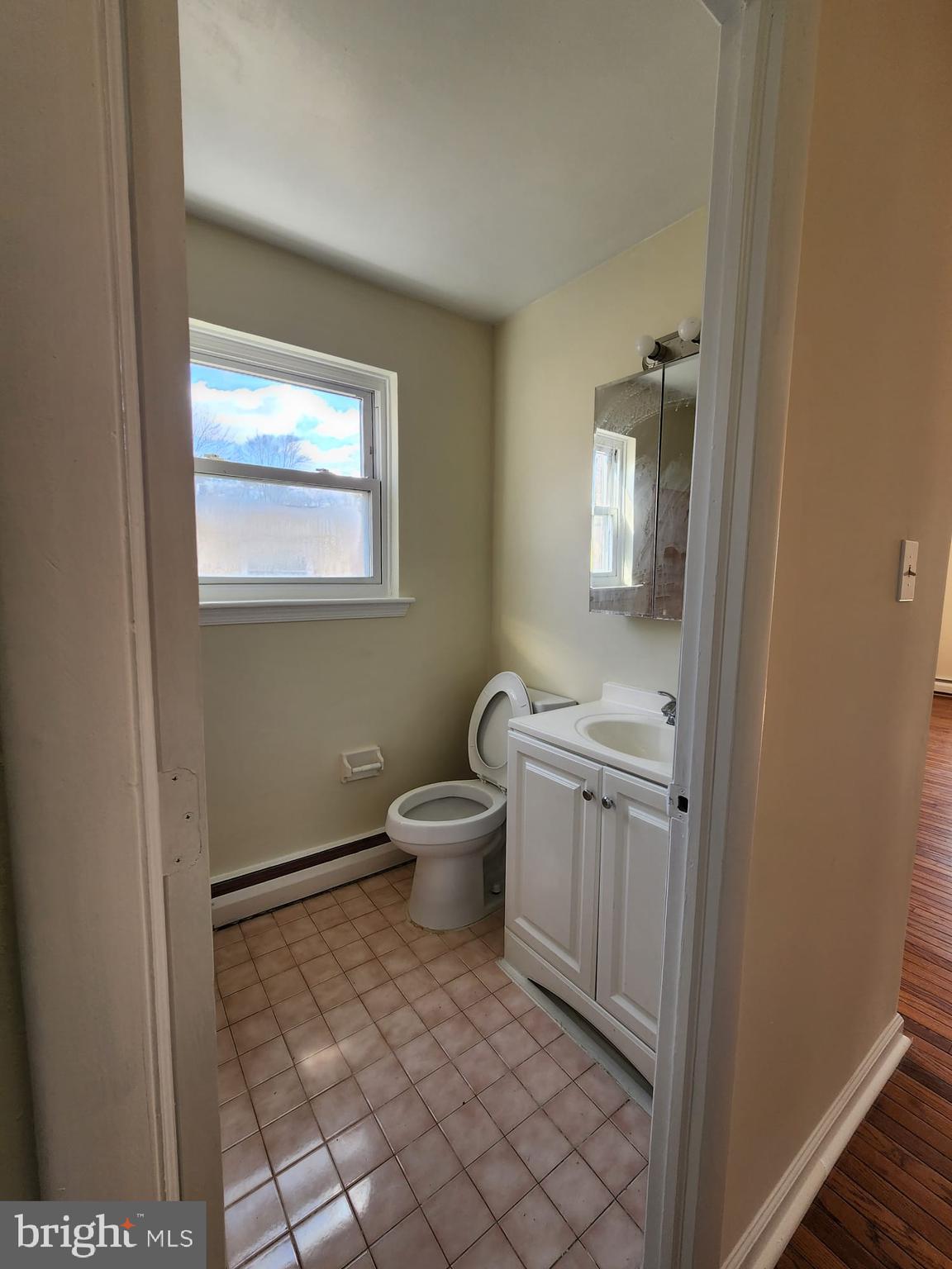 157 Meadowbrook Lane, Unit 2 Brookhaven, PA 19015 - Photo 5 of 13 a bathroom with a toilet sink and mirror