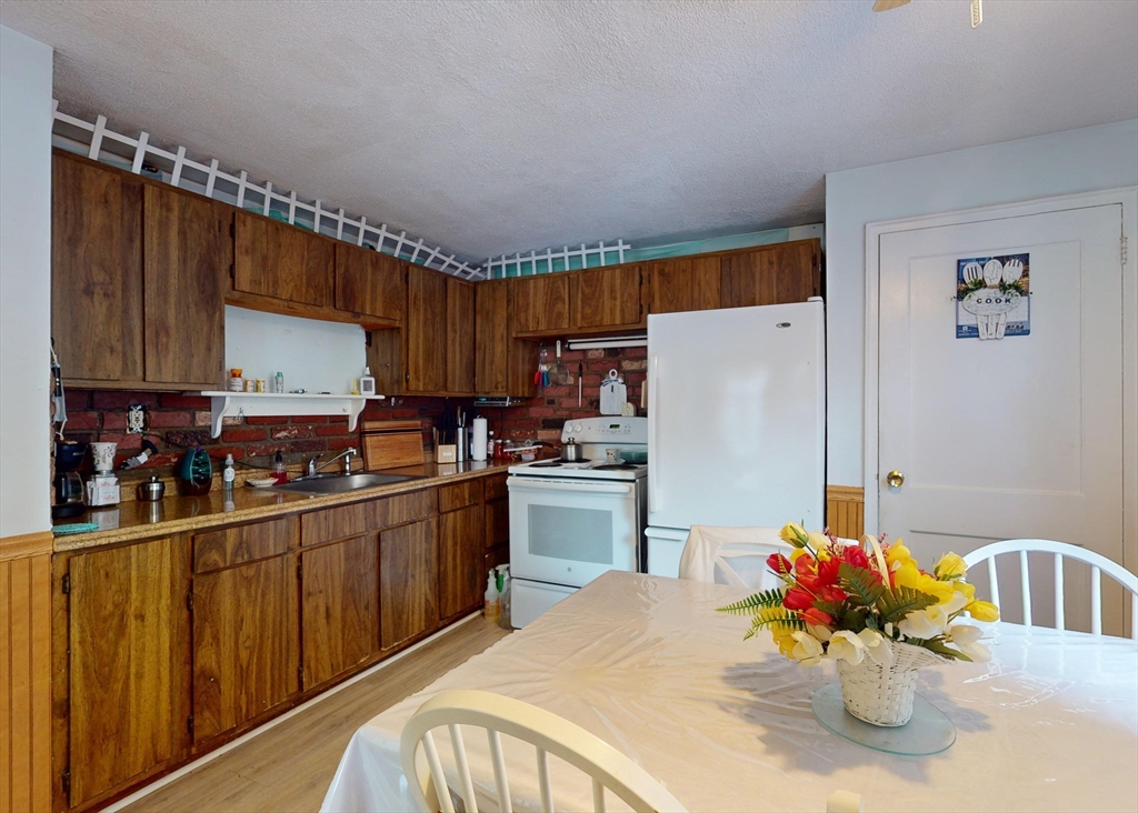 1205 Trapelo Road Waltham, MA 02451 - Photo 8 of 25 a kitchen with refrigerator and cabinets