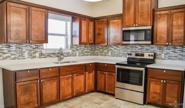 a kitchen with stainless steel appliances granite countertop a stove sink and cabinets
