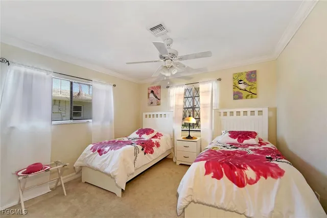 a bedroom with two bed and a window