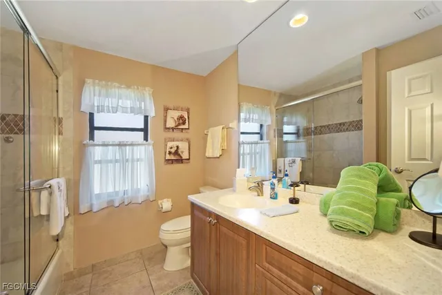 a bathroom with a granite countertop sink a toilet and shower