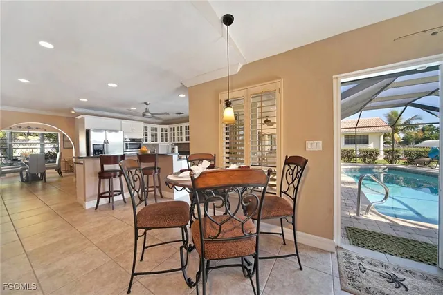 a dining area with furniture and a floor to ceiling window