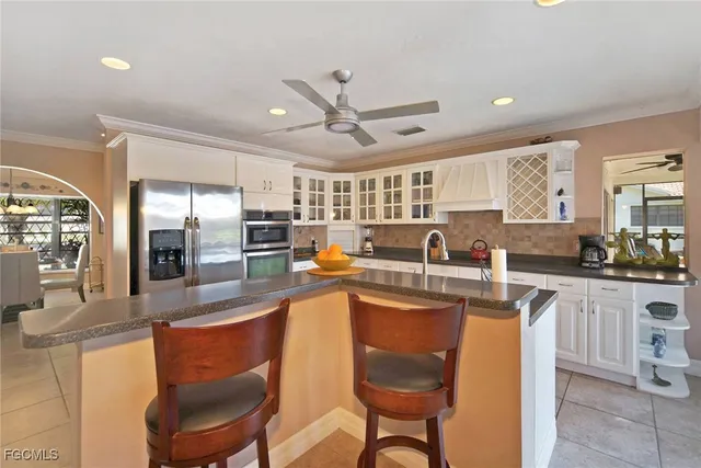 a large kitchen with kitchen island a large counter top space appliances and a center island