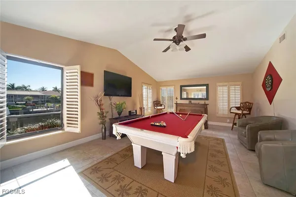 a living room with furniture a flat screen tv and a floor to ceiling window
