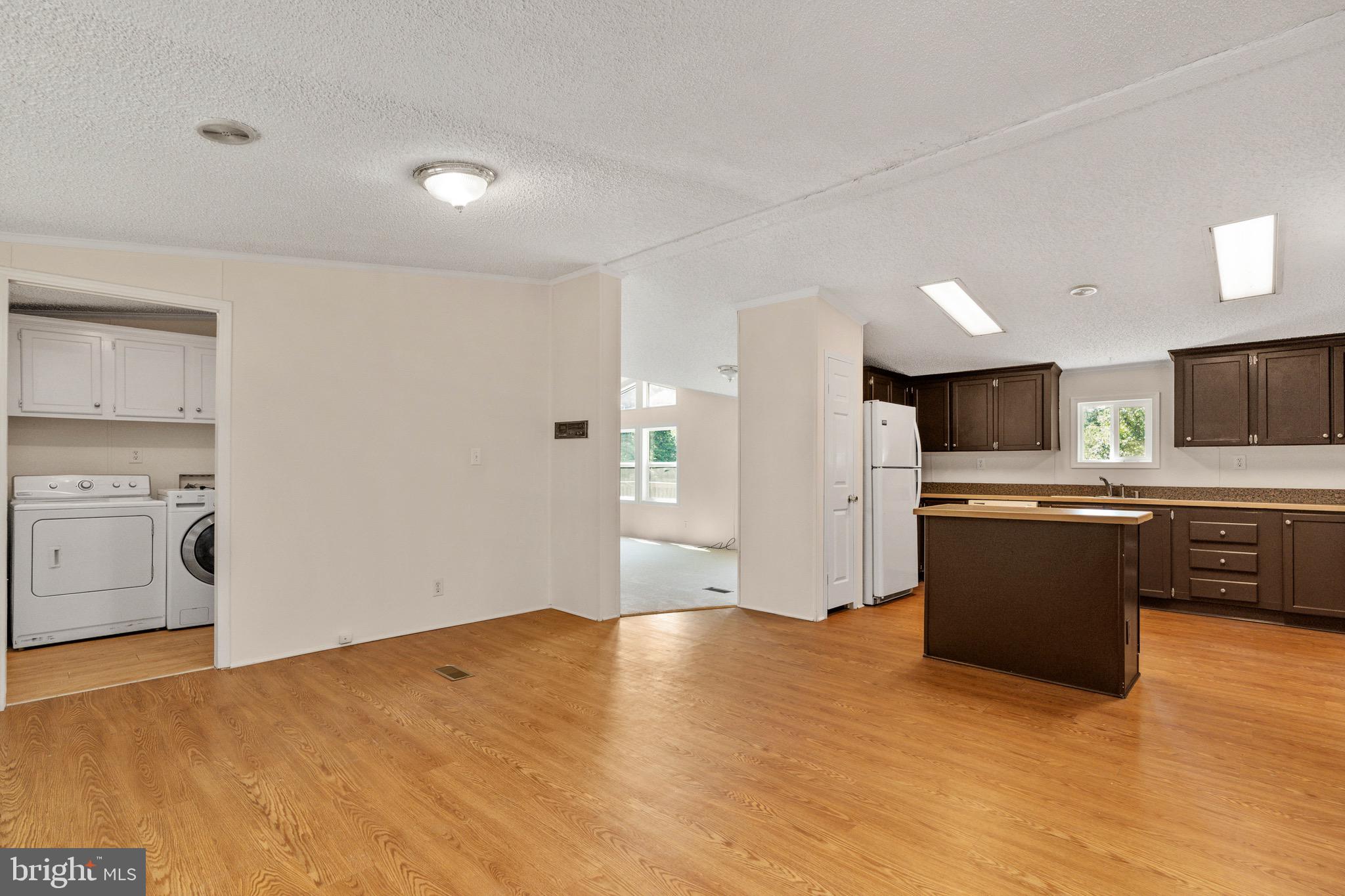 185 Deane Road Louisa, VA 23093 - Photo 20 of 42 a large white kitchen with a stove a sink dishwasher and a refrigerator with wooden floor