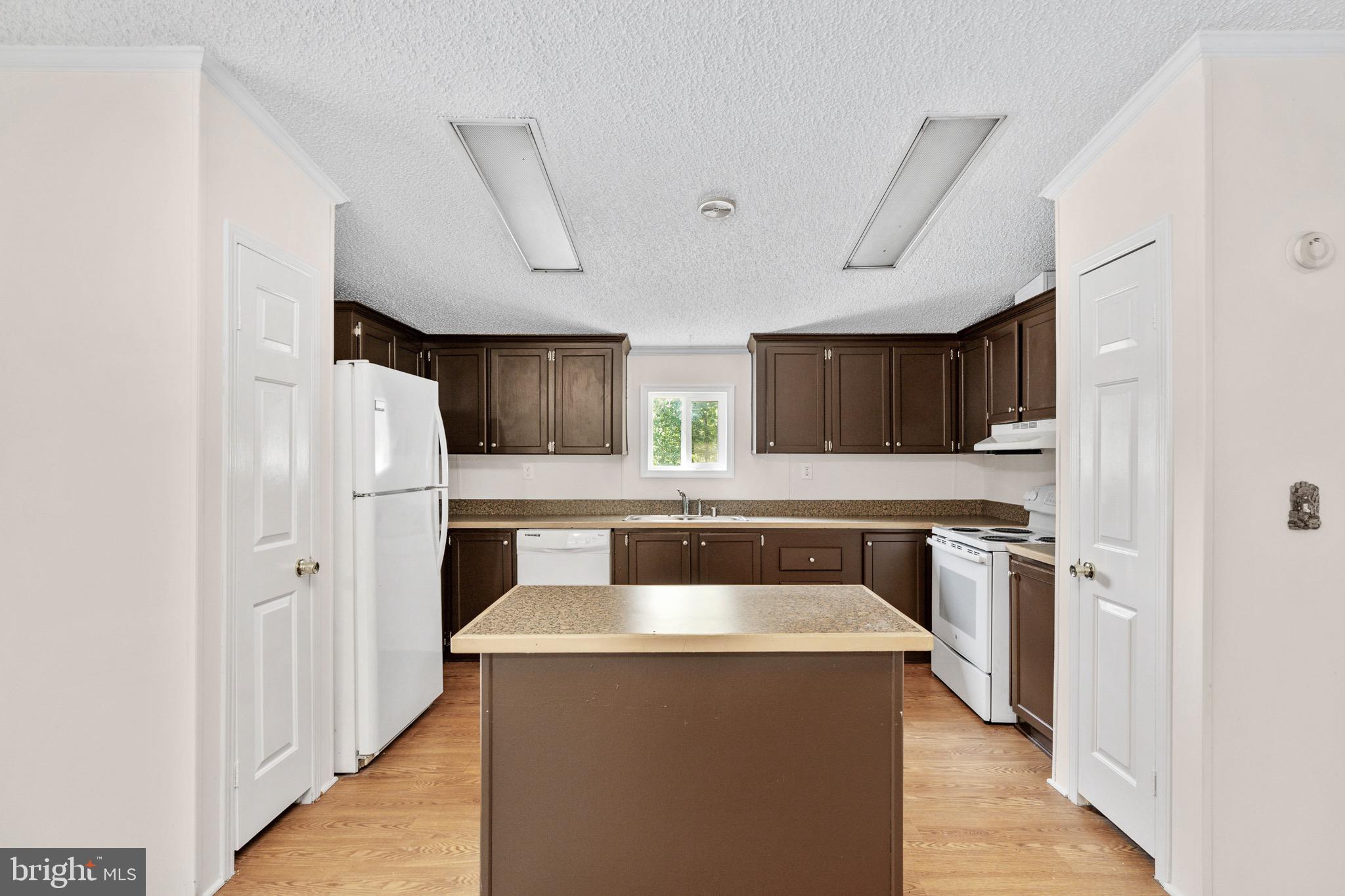 185 Deane Road Louisa, VA 23093 - Photo 21 of 42 a kitchen with stainless steel appliances granite countertop a refrigerator a sink dishwasher a stove and white cabinets with wooden floor