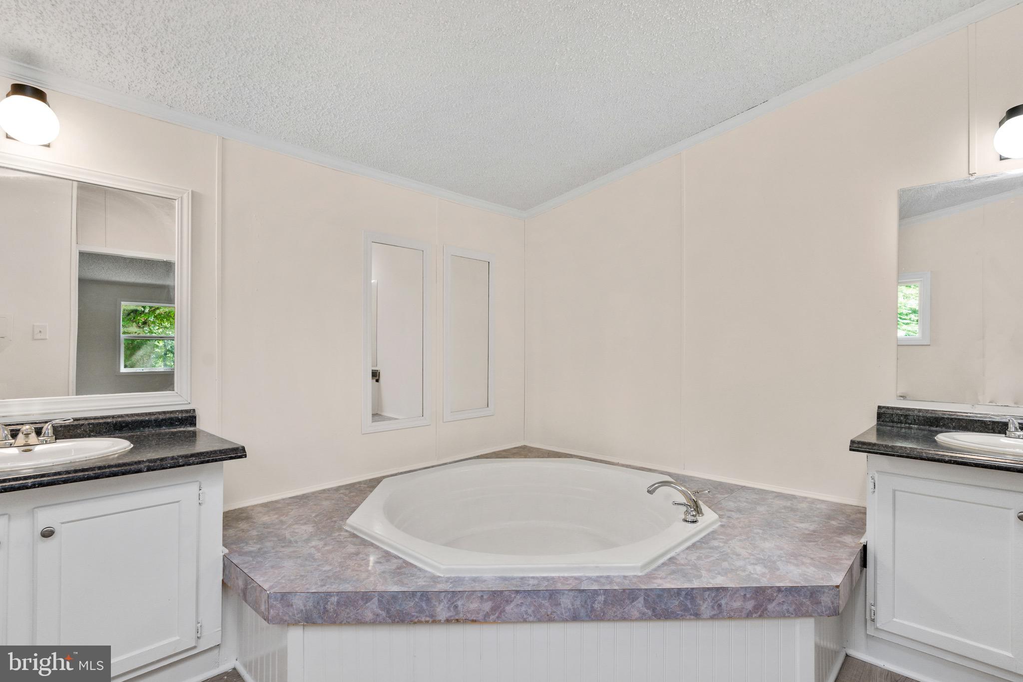 185 Deane Road Louisa, VA 23093 - Photo 38 of 42 a bathroom with a granite countertop sink and white cabinets