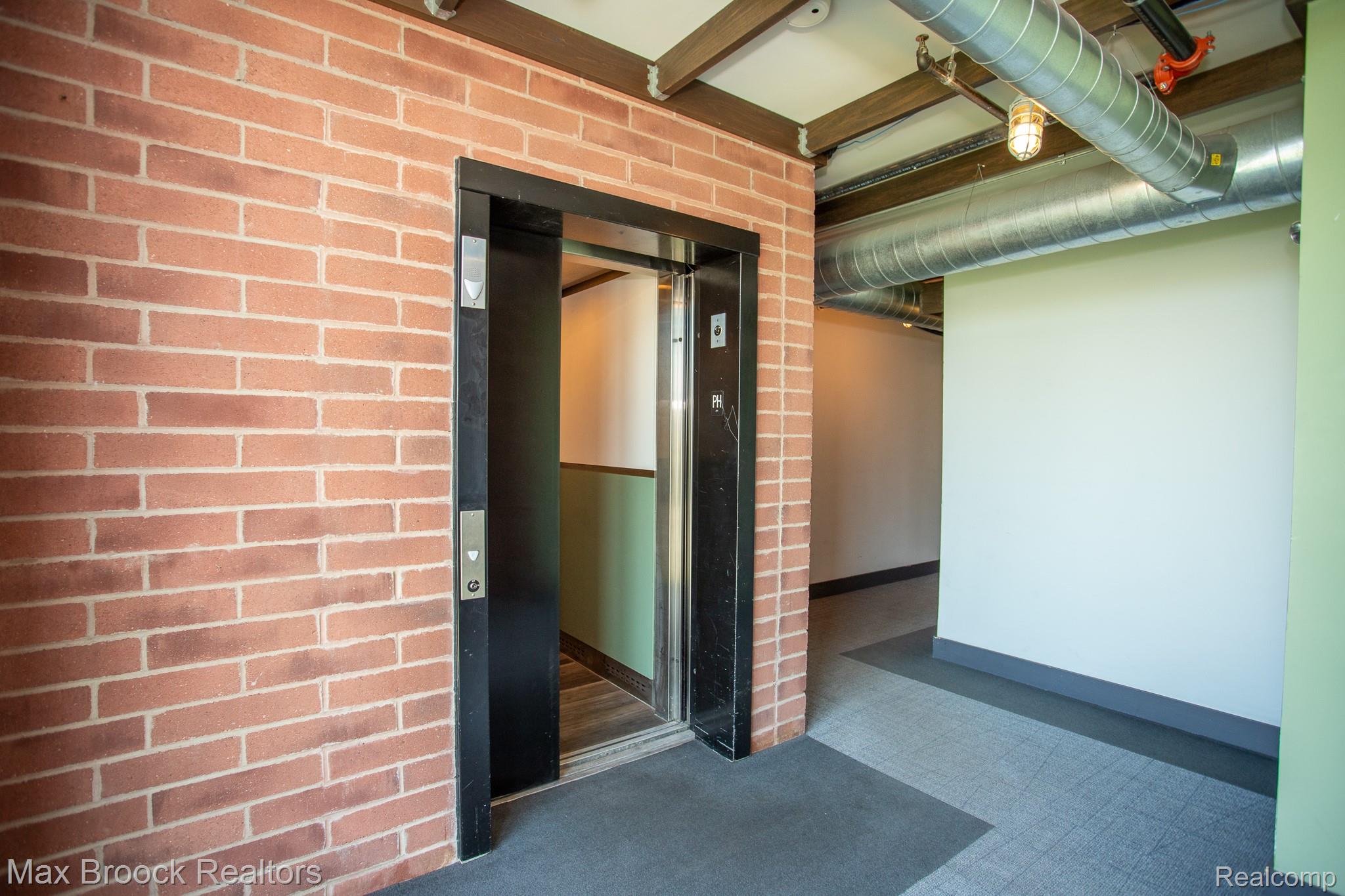 211 East 9 Mile Road, Unit 307 Ferndale, MI 48220 - Photo 5 of 60 Doorway to property with elevator and brick siding