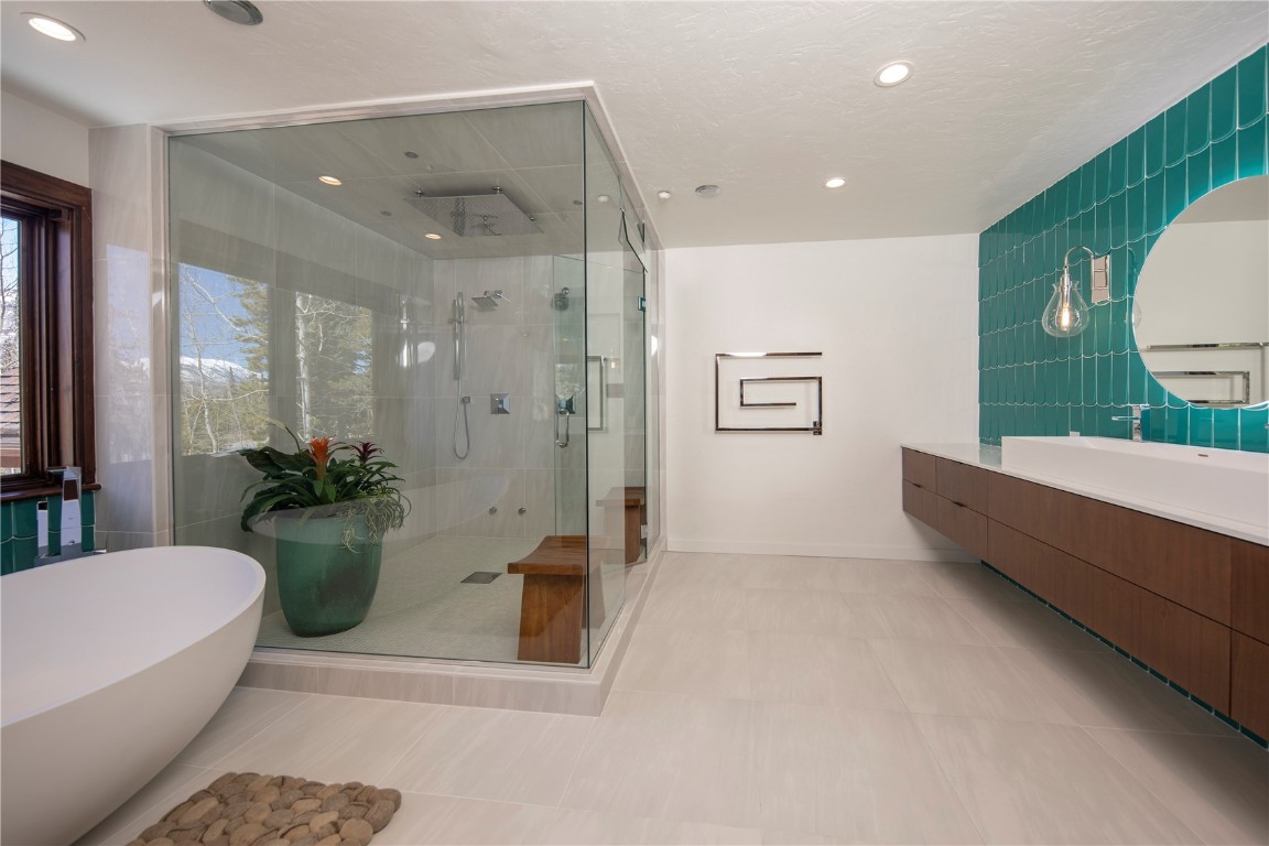 525 Two Cabins Drive Silverthorne, CO 80498 - Photo 22 of 35 a bathroom with a tub shower sink and mirror