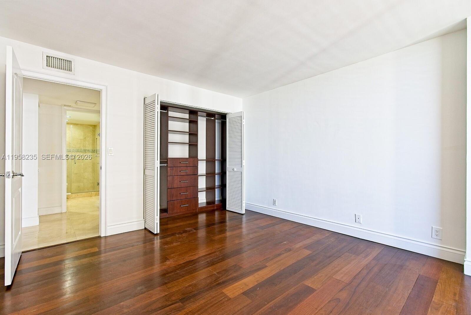 1925 Brickell Avenue, Unit D1201 Miami, FL 33129 - Photo 14 of 27 a view of an empty room with wooden floor and a window