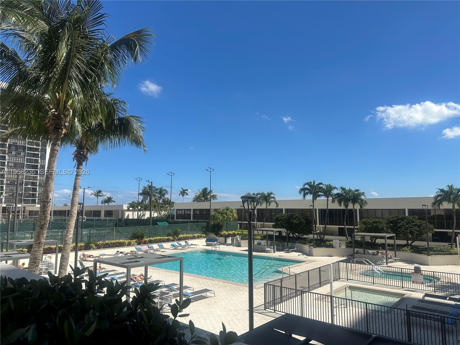 1925 Brickell Avenue, Unit D1201 Miami, FL 33129 - Photo 19 of 27 a view of a swimming pool with a lawn chairs under an umbrella