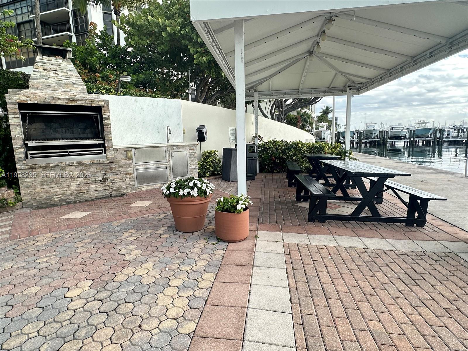 1925 Brickell Avenue, Unit D1201 Miami, FL 33129 - Photo 24 of 27 a view of a patio with table and chairs potted plants