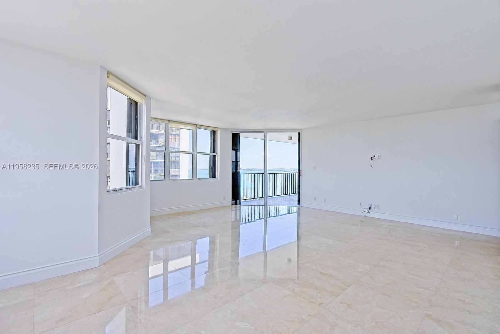 1925 Brickell Avenue, Unit D1201 Miami, FL 33129 - Photo 4 of 27 an empty room with chandelier fan and windows