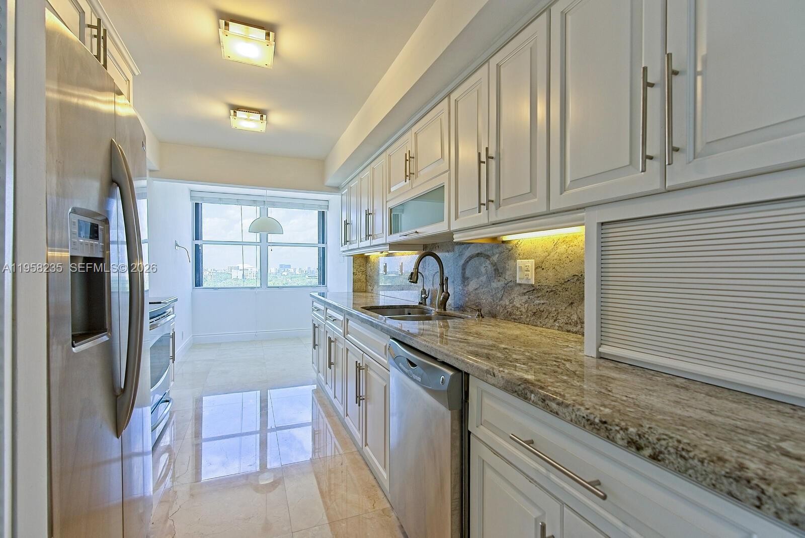 1925 Brickell Avenue, Unit D1201 Miami, FL 33129 - Photo 6 of 27 a kitchen with stainless steel appliances granite countertop a stove a refrigerator and a sink