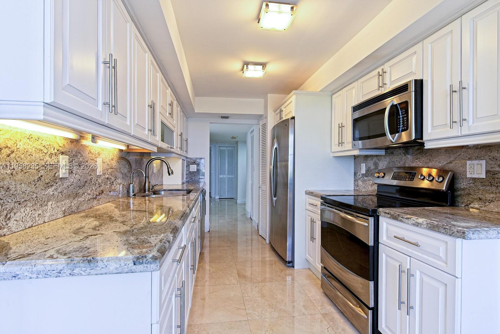 1925 Brickell Avenue, Unit D1201 Miami, FL 33129 - Photo 7 of 27 a kitchen with stainless steel appliances granite countertop a stove a sink and a microwave