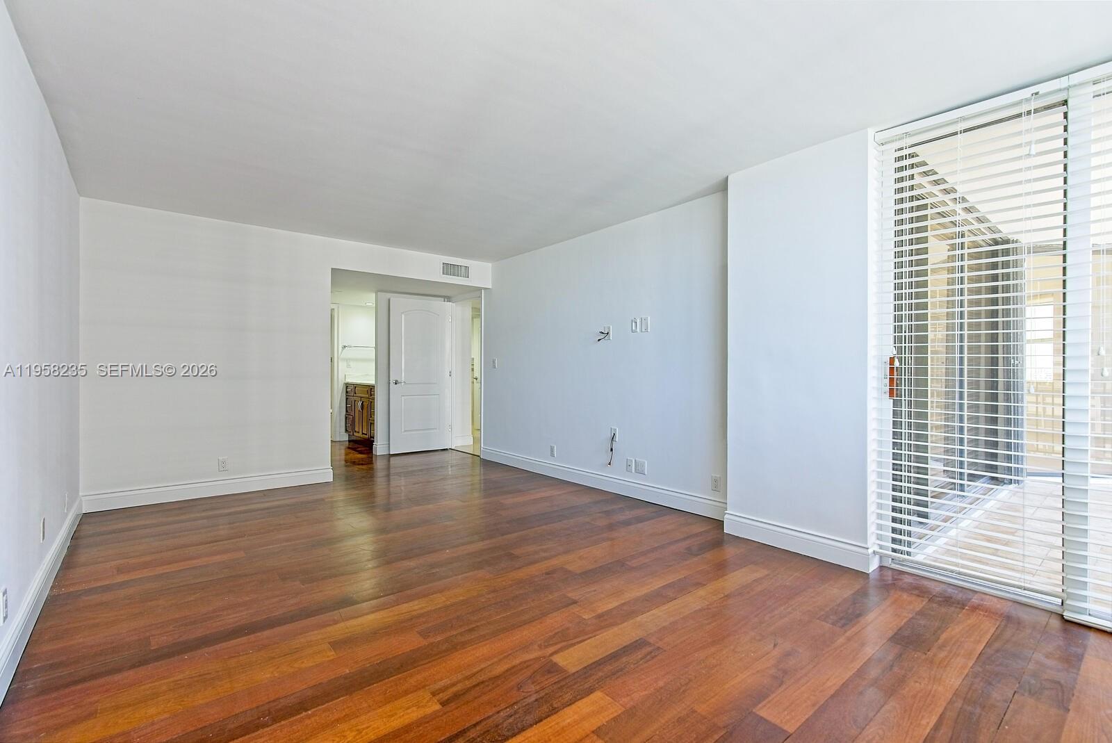 1925 Brickell Avenue, Unit D1201 Miami, FL 33129 - Photo 9 of 27 a view of an empty room with wooden floor and a window