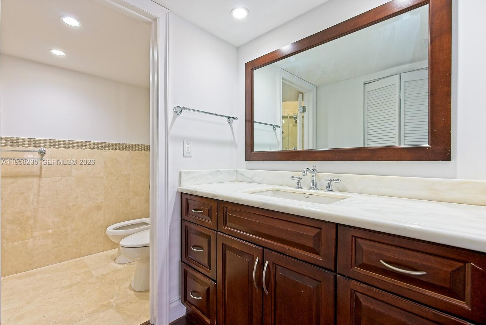 1925 Brickell Avenue, Unit D1201 Miami, FL 33129 - Photo 10 of 27 a bathroom with a sink a toilet a mirror and shower