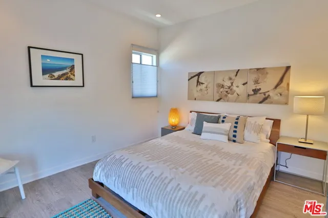 a bedroom with a bed and painting on the wall