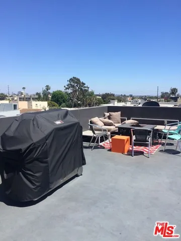 a view of a terrace with lawn chairs