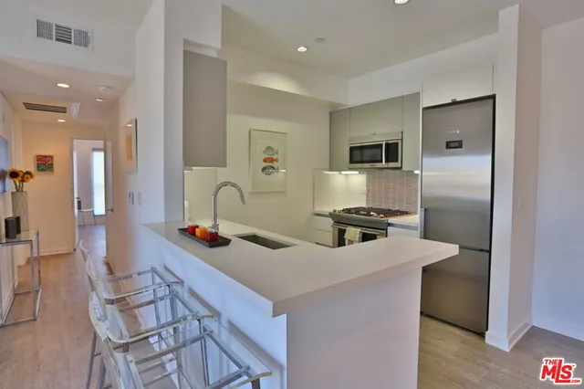 a kitchen with stainless steel appliances granite countertop a sink a stove and a refrigerator