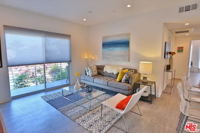 a living room with furniture and a floor to ceiling window