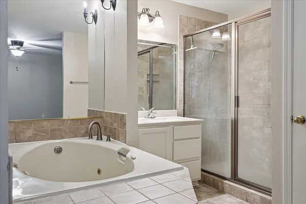a bathroom with a tub a sink and mirror