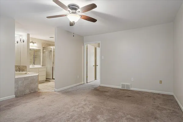 a view of a big room with chandelier fan and windows