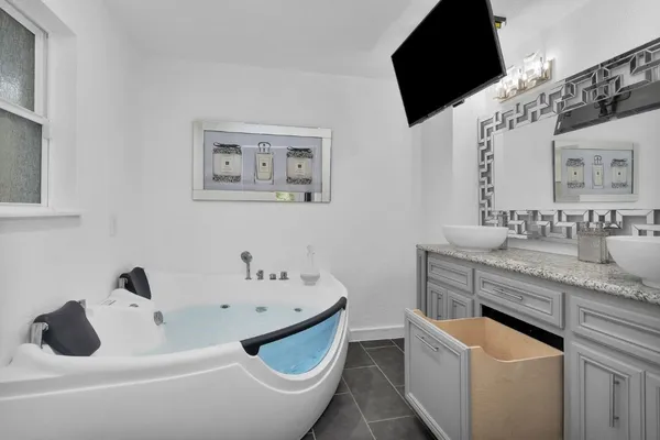 a bathroom with a granite countertop sink and a mirror