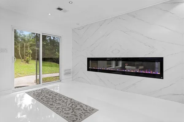 a living room with a fireplace and a large window